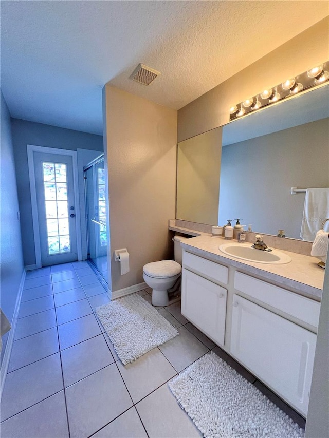 bathroom featuring walk in shower, a textured ceiling, vanity, tile patterned floors, and toilet