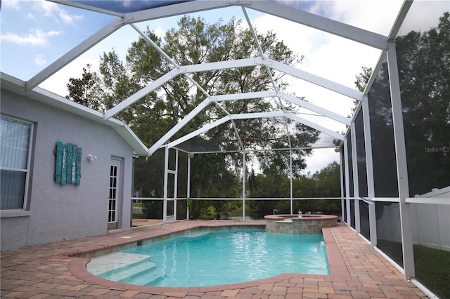 view of pool featuring a patio, a lanai, and an in ground hot tub