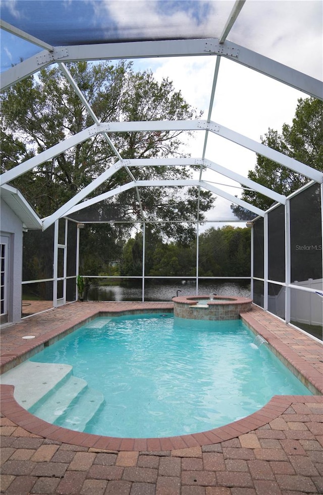 view of pool with glass enclosure, a patio, and an in ground hot tub