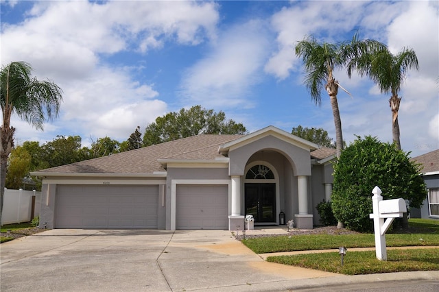 ranch-style house featuring a garage and a front lawn