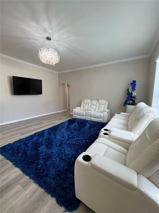 living room featuring hardwood / wood-style floors, a textured ceiling, an inviting chandelier, and crown molding