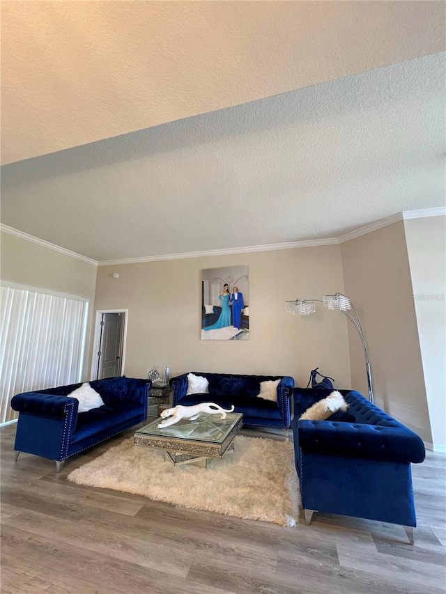 living room with hardwood / wood-style floors, a textured ceiling, and ornamental molding