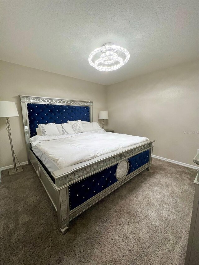 bedroom with dark colored carpet and a textured ceiling