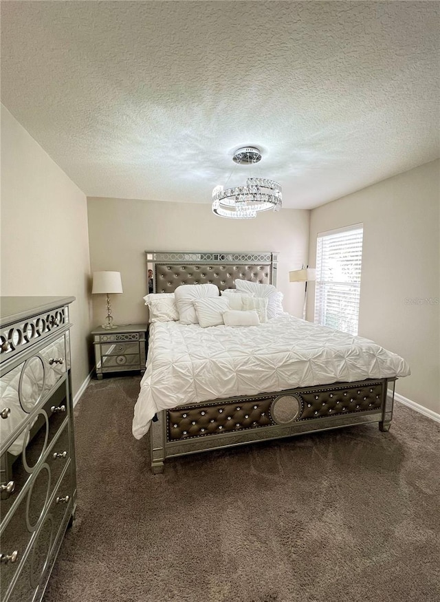 bedroom with a notable chandelier, a textured ceiling, and dark carpet