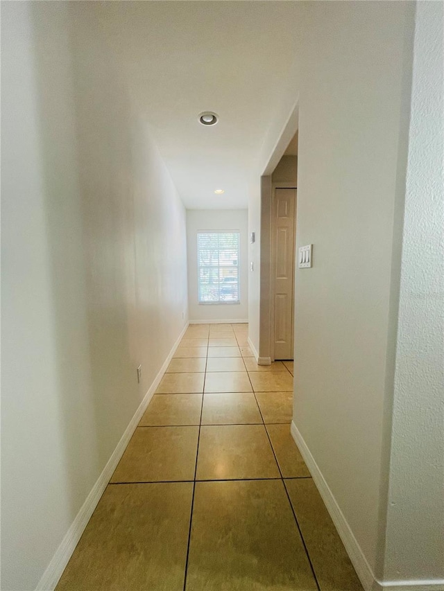 hall with light tile patterned floors