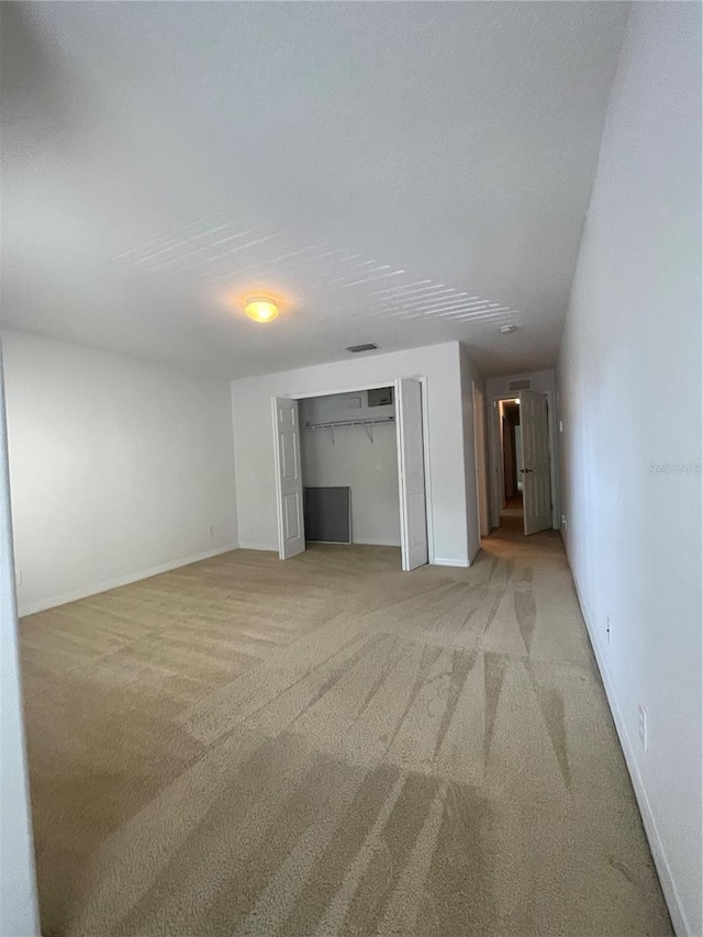 unfurnished living room with light colored carpet