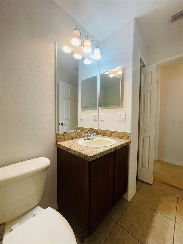 bathroom featuring vanity, tile patterned floors, and toilet