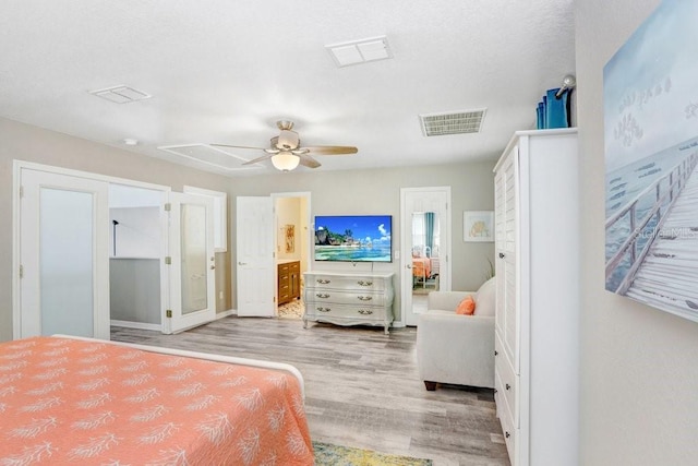 bedroom featuring light hardwood / wood-style floors, ensuite bath, and ceiling fan