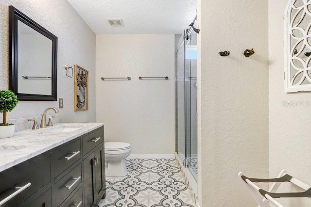 bathroom with vanity, an enclosed shower, toilet, a textured ceiling, and tile patterned flooring