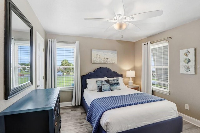 bedroom featuring multiple windows, ceiling fan, and hardwood / wood-style floors