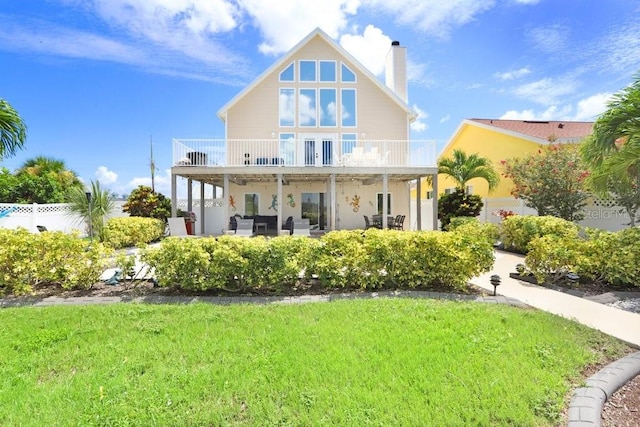 rear view of property featuring a patio and a lawn