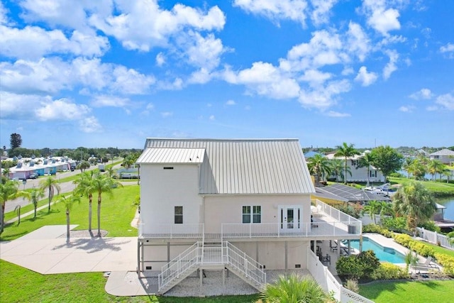 rear view of property featuring a garage, a yard, a patio, and a fenced in pool