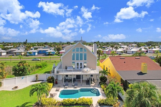 back of property featuring a patio and a fenced in pool