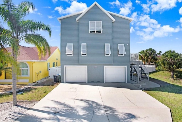 exterior space featuring concrete driveway, stucco siding, an attached garage, and stairs