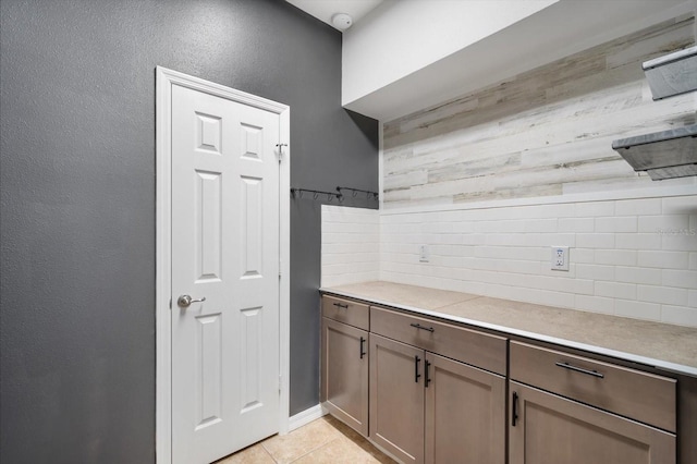 kitchen with light countertops, decorative backsplash, and light tile patterned floors