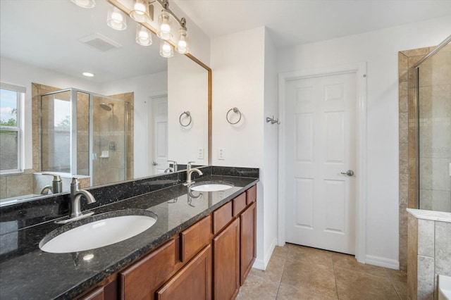 bathroom with tile patterned floors, a sink, visible vents, and a shower stall