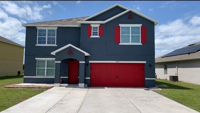 view of front of property with a front yard, a garage, central AC unit, and solar panels