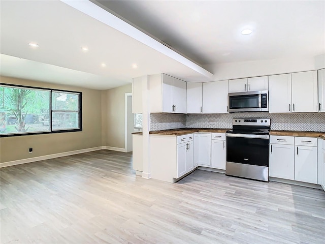 kitchen with backsplash, light wood-type flooring, white cabinetry, and appliances with stainless steel finishes