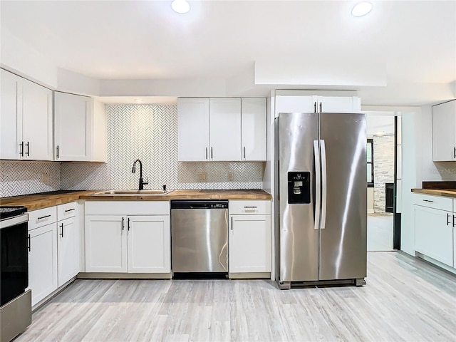 kitchen featuring sink, white cabinetry, butcher block countertops, and stainless steel appliances