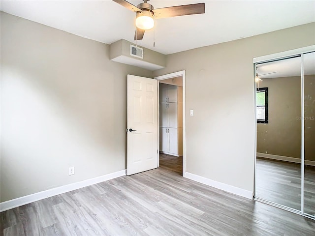 unfurnished bedroom with light hardwood / wood-style floors, a closet, and ceiling fan