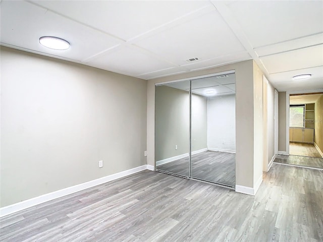 unfurnished bedroom featuring light hardwood / wood-style flooring and a closet