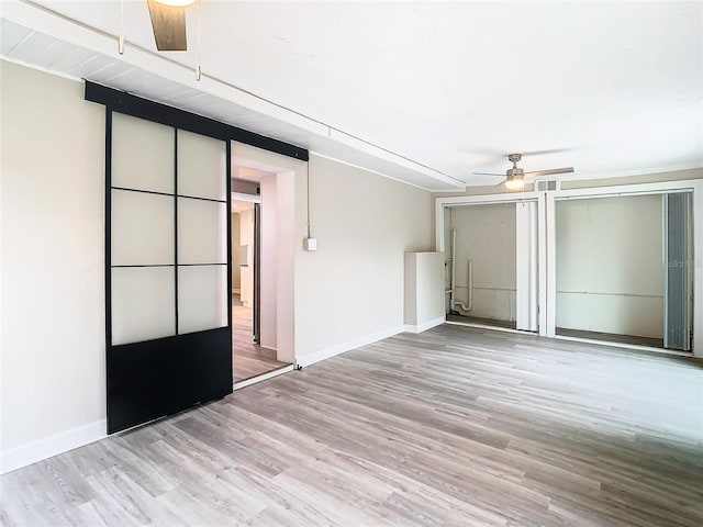 empty room with light hardwood / wood-style floors and ceiling fan