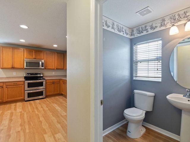 interior space with sink, hardwood / wood-style flooring, and toilet