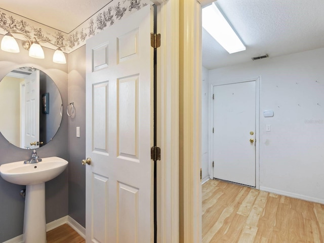 bathroom featuring hardwood / wood-style floors and a textured ceiling