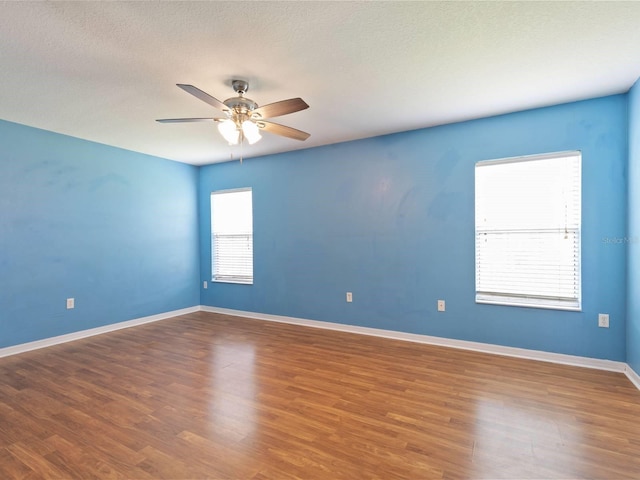 empty room with hardwood / wood-style flooring, a textured ceiling, and ceiling fan