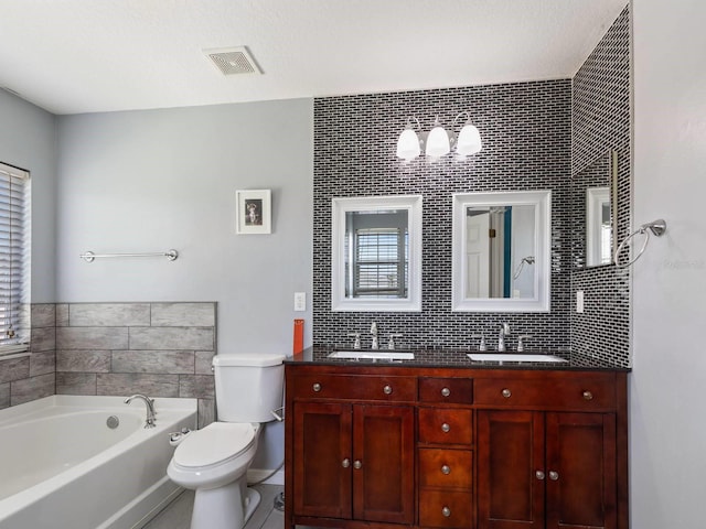 bathroom with tasteful backsplash, vanity, a bathtub, and toilet