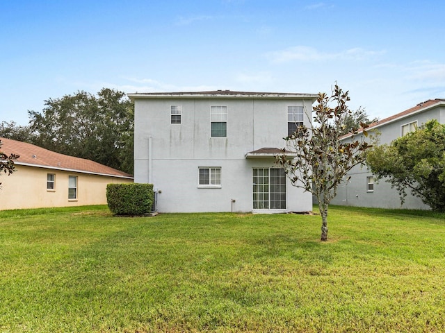 rear view of property featuring a yard