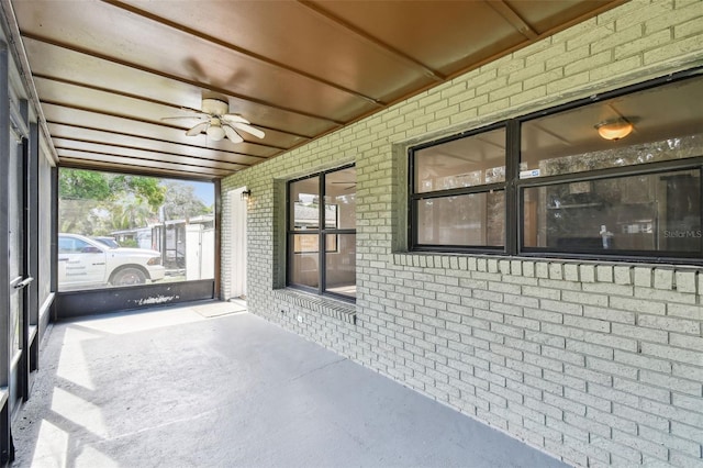 unfurnished sunroom featuring ceiling fan