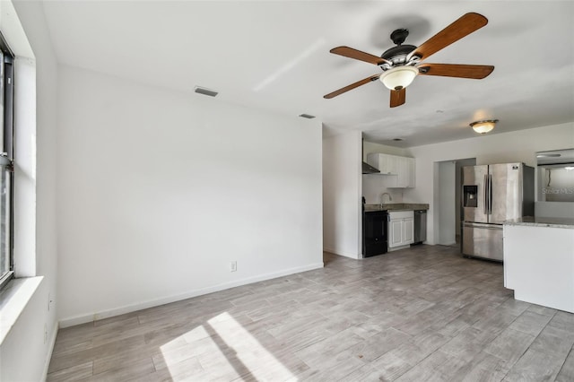 unfurnished living room with ceiling fan, light hardwood / wood-style floors, and sink