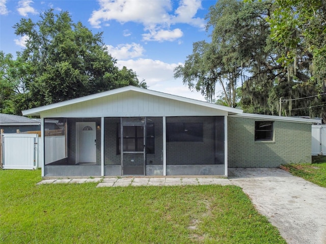 back of house featuring a yard and a sunroom