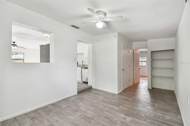 unfurnished living room featuring ceiling fan, sink, and light hardwood / wood-style floors