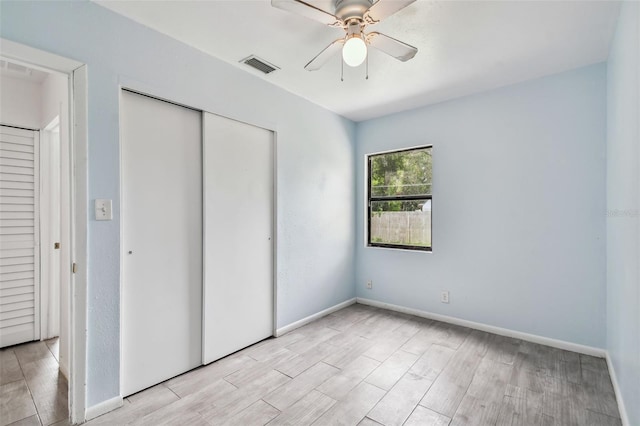 unfurnished bedroom featuring ceiling fan, a closet, and light wood-type flooring