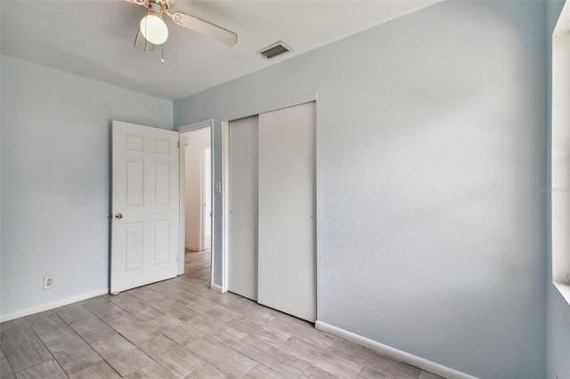 unfurnished bedroom featuring ceiling fan, a closet, and light hardwood / wood-style floors