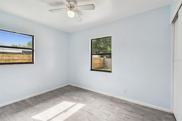 spare room featuring light hardwood / wood-style flooring, plenty of natural light, and ceiling fan