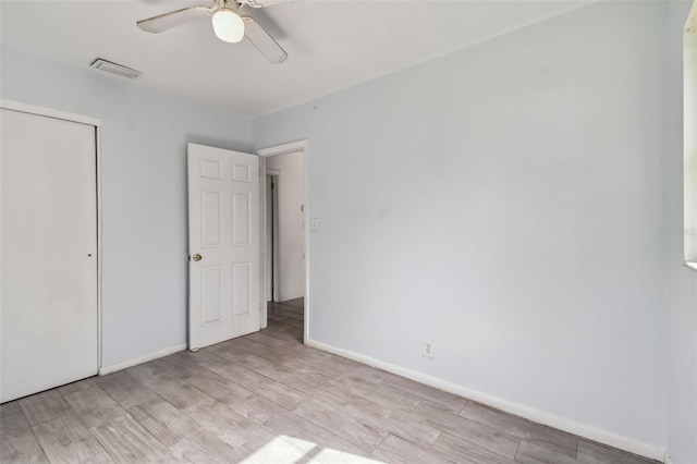 unfurnished bedroom featuring a closet, light hardwood / wood-style floors, and ceiling fan