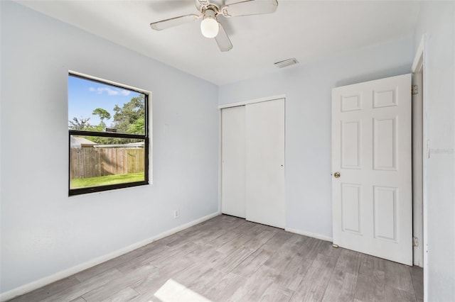 unfurnished bedroom with light wood-type flooring, a closet, and ceiling fan