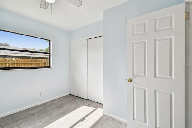 unfurnished bedroom featuring ceiling fan, a closet, and light hardwood / wood-style floors