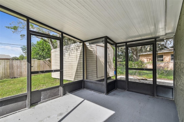 unfurnished sunroom featuring plenty of natural light and lofted ceiling