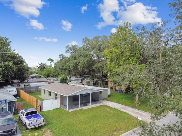 back of property featuring a sunroom and a yard