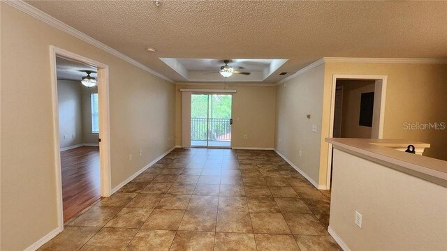 hall featuring light tile patterned flooring, a raised ceiling, and ornamental molding