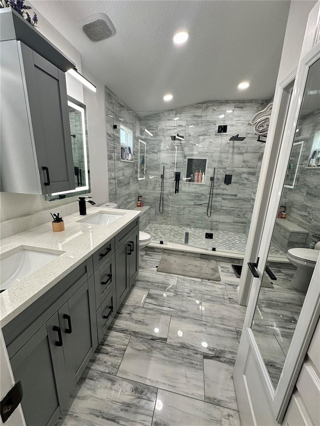 bathroom with an enclosed shower, vanity, a textured ceiling, and toilet