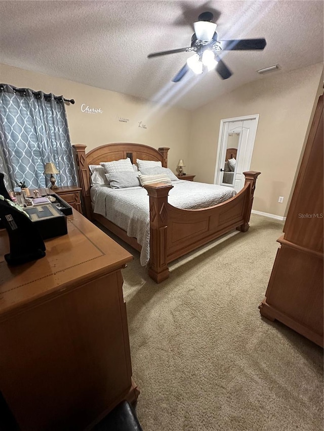 bedroom with lofted ceiling, a textured ceiling, ceiling fan, and carpet flooring