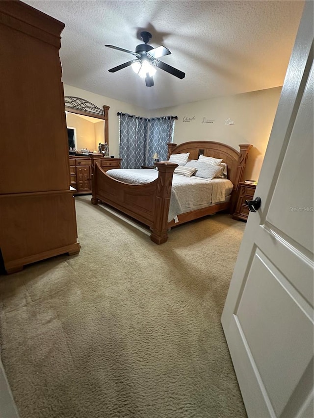 bedroom featuring carpet flooring, a textured ceiling, and ceiling fan