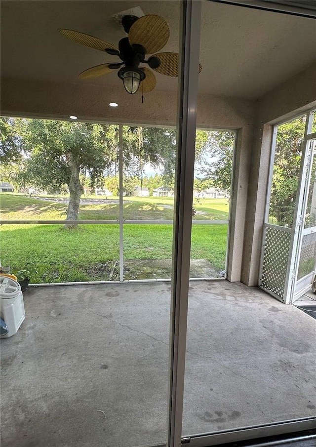 unfurnished sunroom with ceiling fan