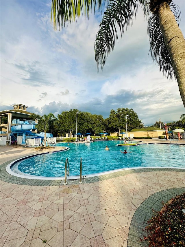 view of pool featuring a patio area and a water slide