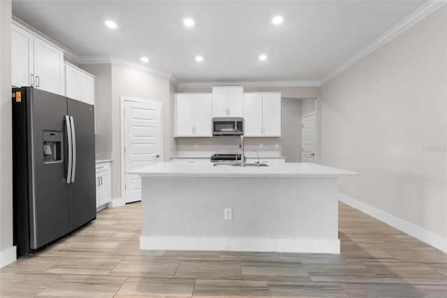 kitchen with crown molding, white cabinets, a center island with sink, and stainless steel appliances